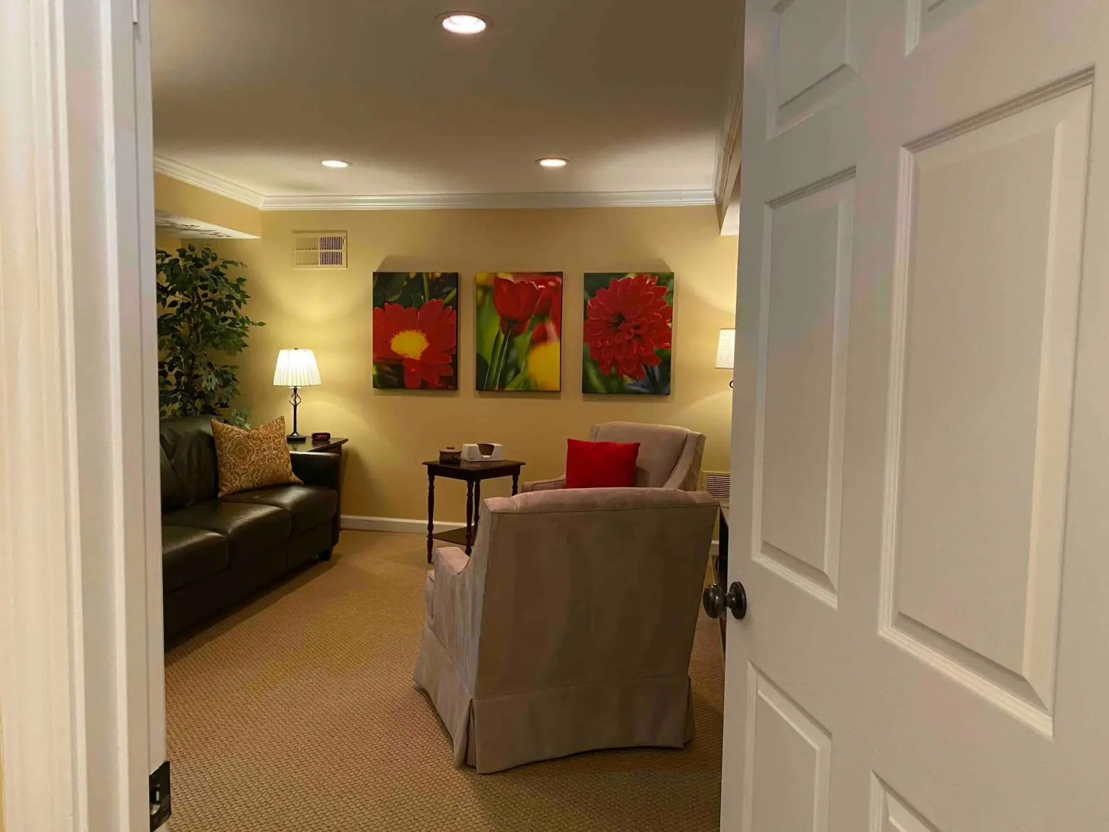Gail A. Phillips' Buckhead consulting room — two upholstered chairs and a leather sofa under warm lamplight
